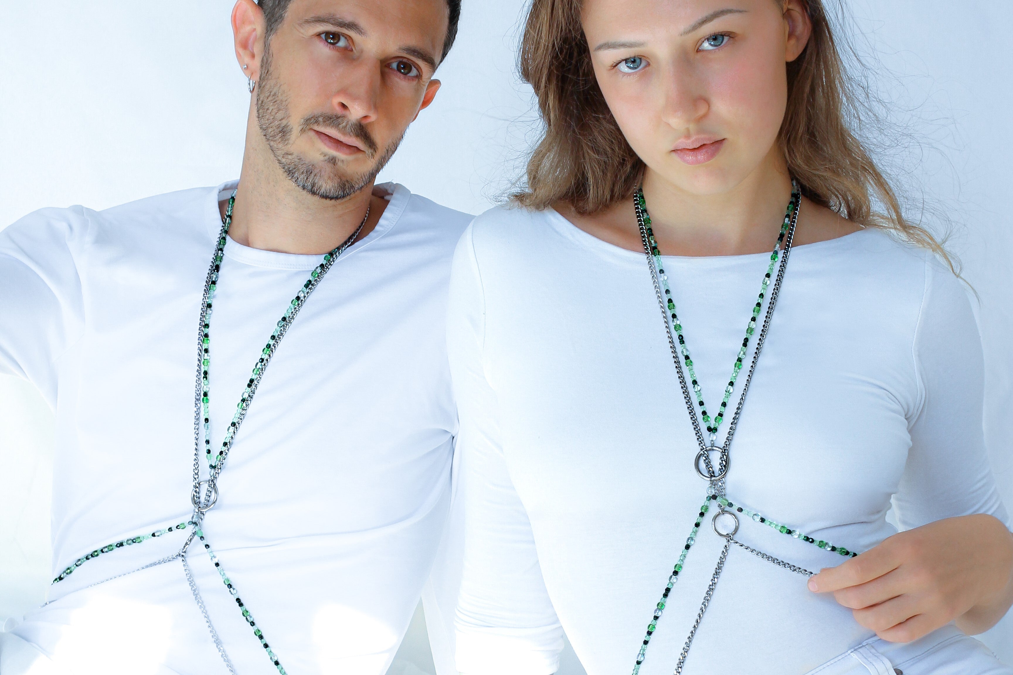 Azure Collection Photo of female model Luisa Hill and male model Jerome Dureault wearing SOIRA jewlry. Models are dressed in white in front of white background wearing SOIRA body chains