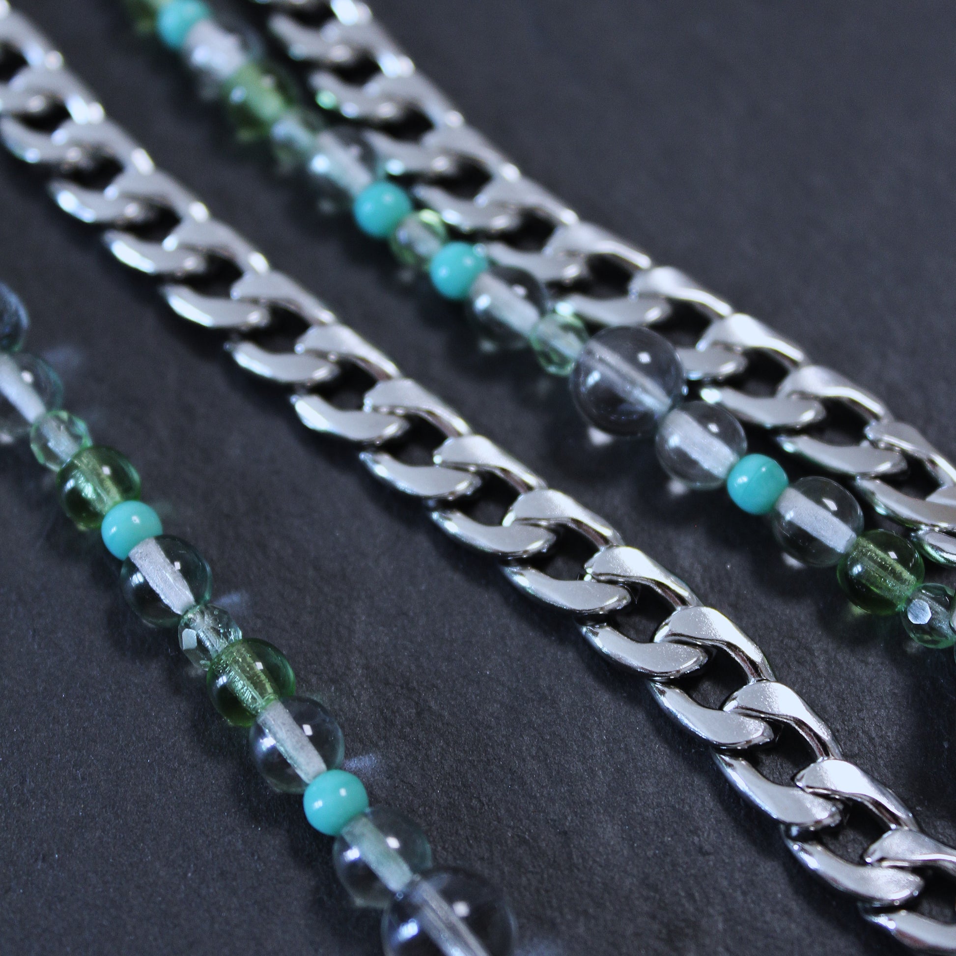 Detail Foto von einem SOIRA Produkt auf dunklem Hintergrund. Produktfoto Zoom. Edelstahlkette und Glasperlen